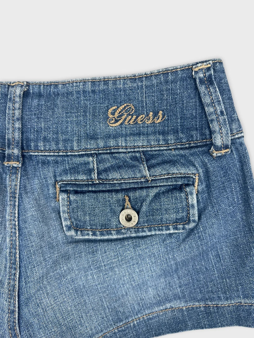 Detail view of women's denim shorts featuring light blue fabric and back pocket.