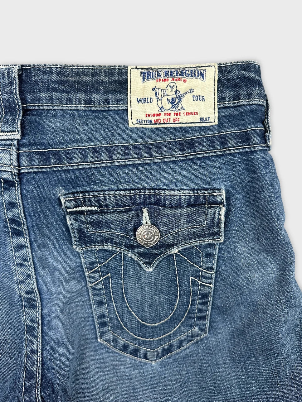 Detail view of women denim shorts in blue featuring a back pocket design.