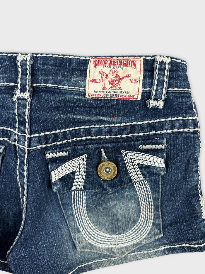 Detail view of women's denim shorts in blue featuring unique stitching and pockets.