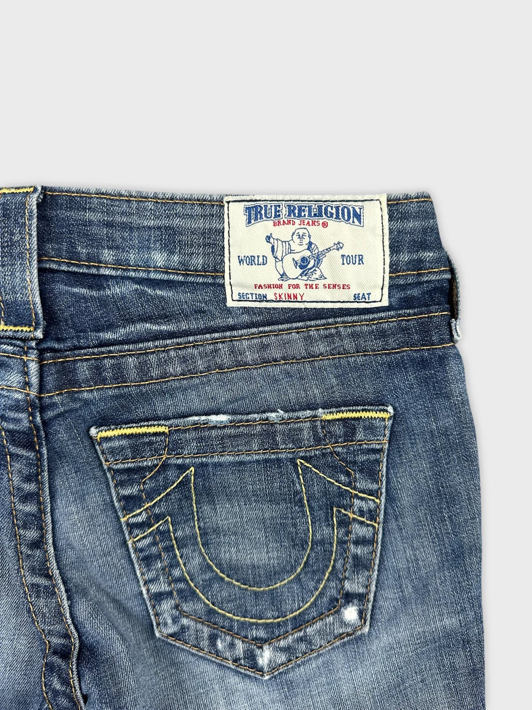 Detail view of women denim shorts in light blue with unique back pocket stitching.