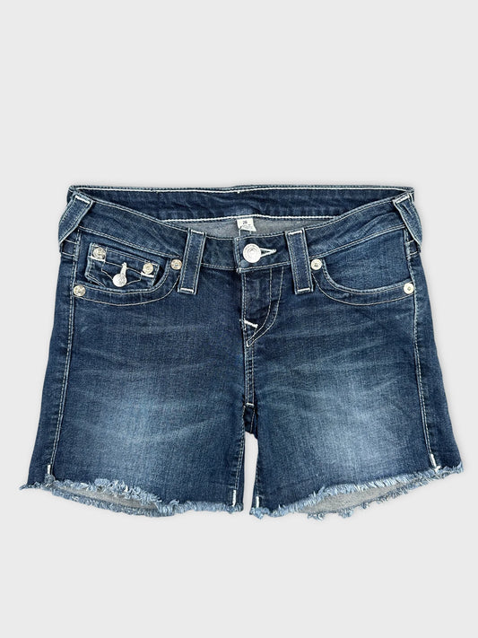 Front view of women denim shorts in dark blue with frayed hem.
