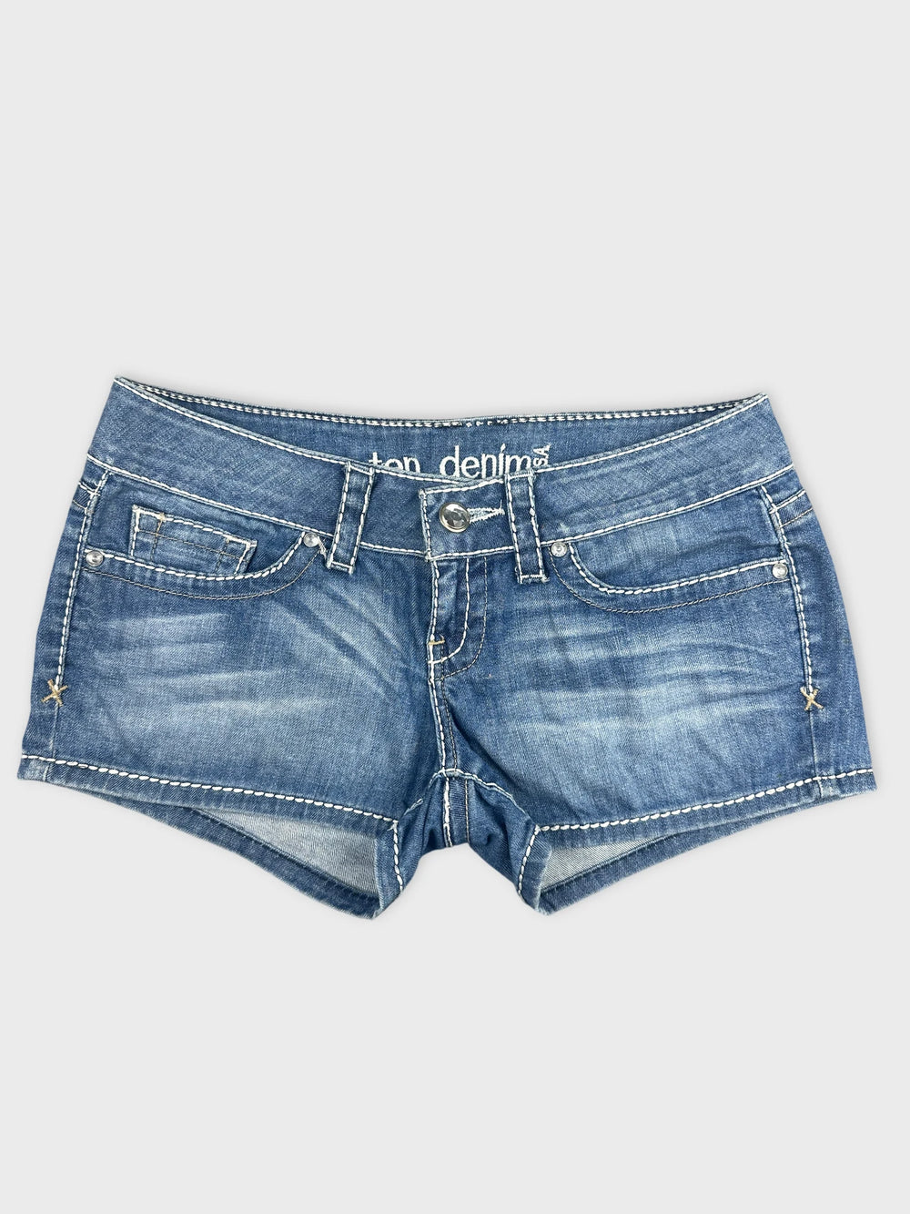 Front view of denim shorts featuring a faded blue color and white stitching.