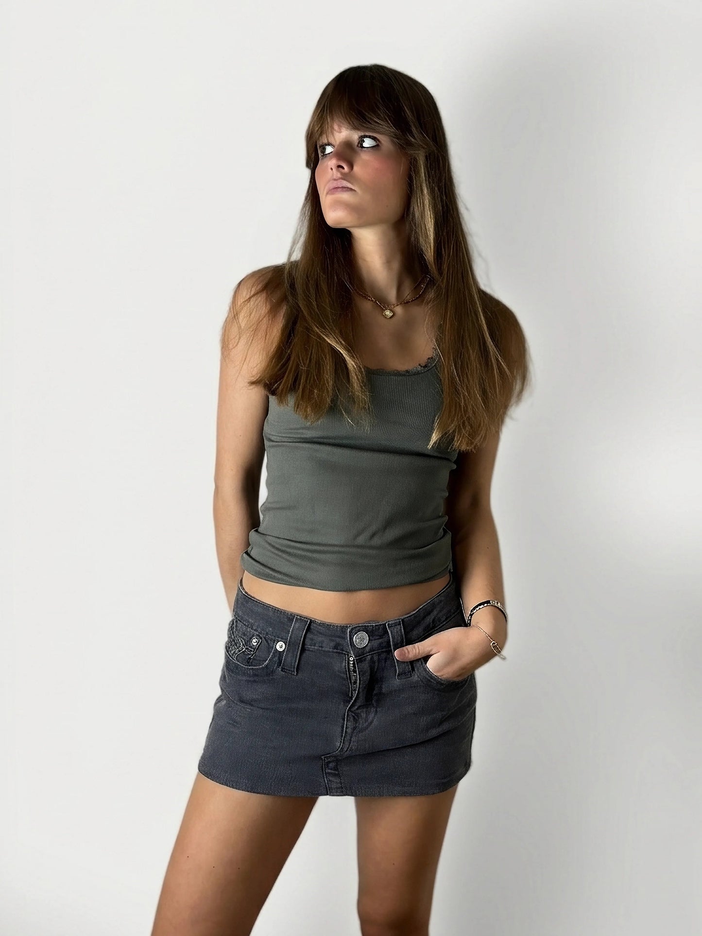 Front view of a women denim skirt in dark wash with front pockets.