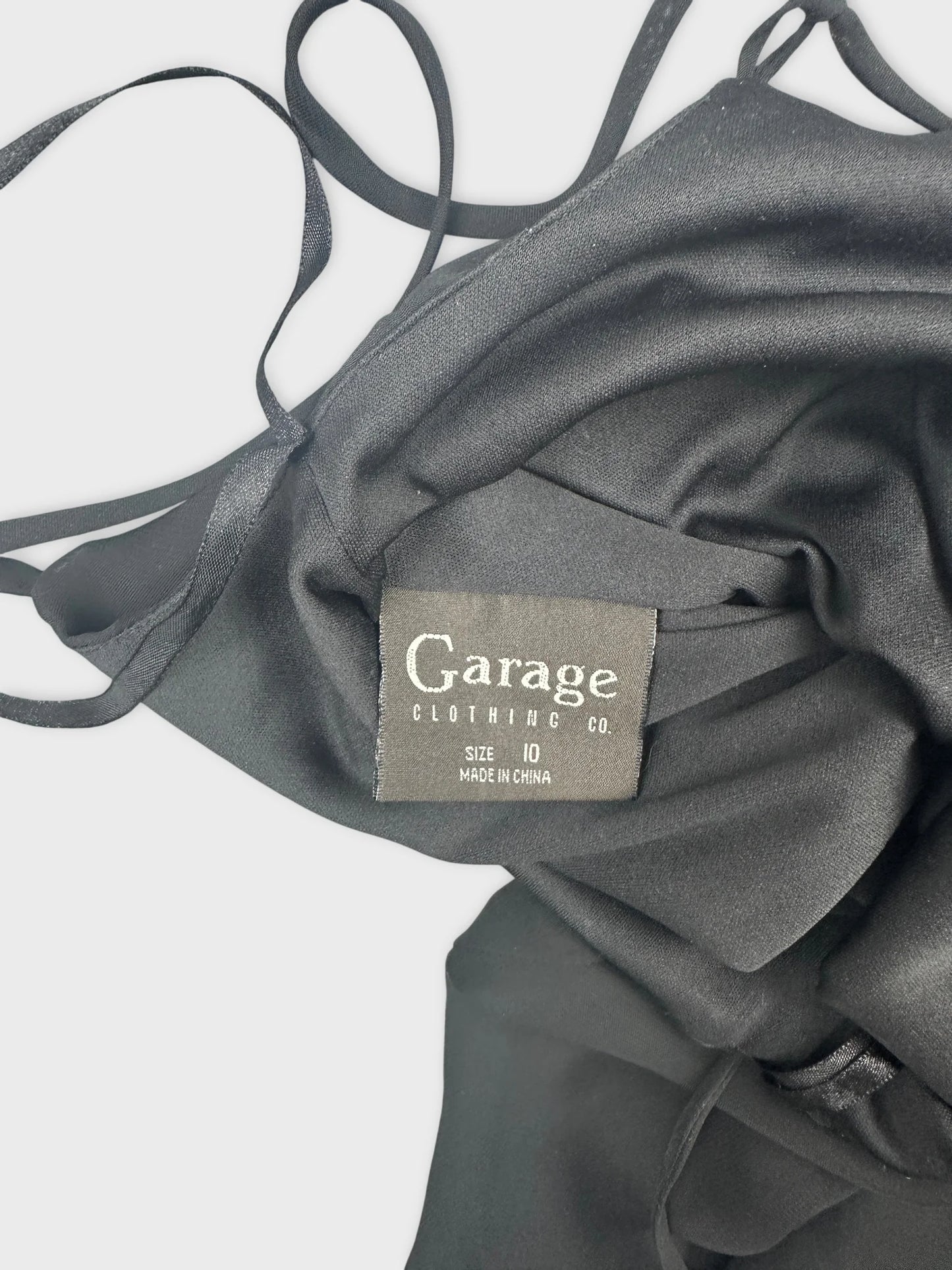 Detail view of a black long dress showcasing satin texture and straps.