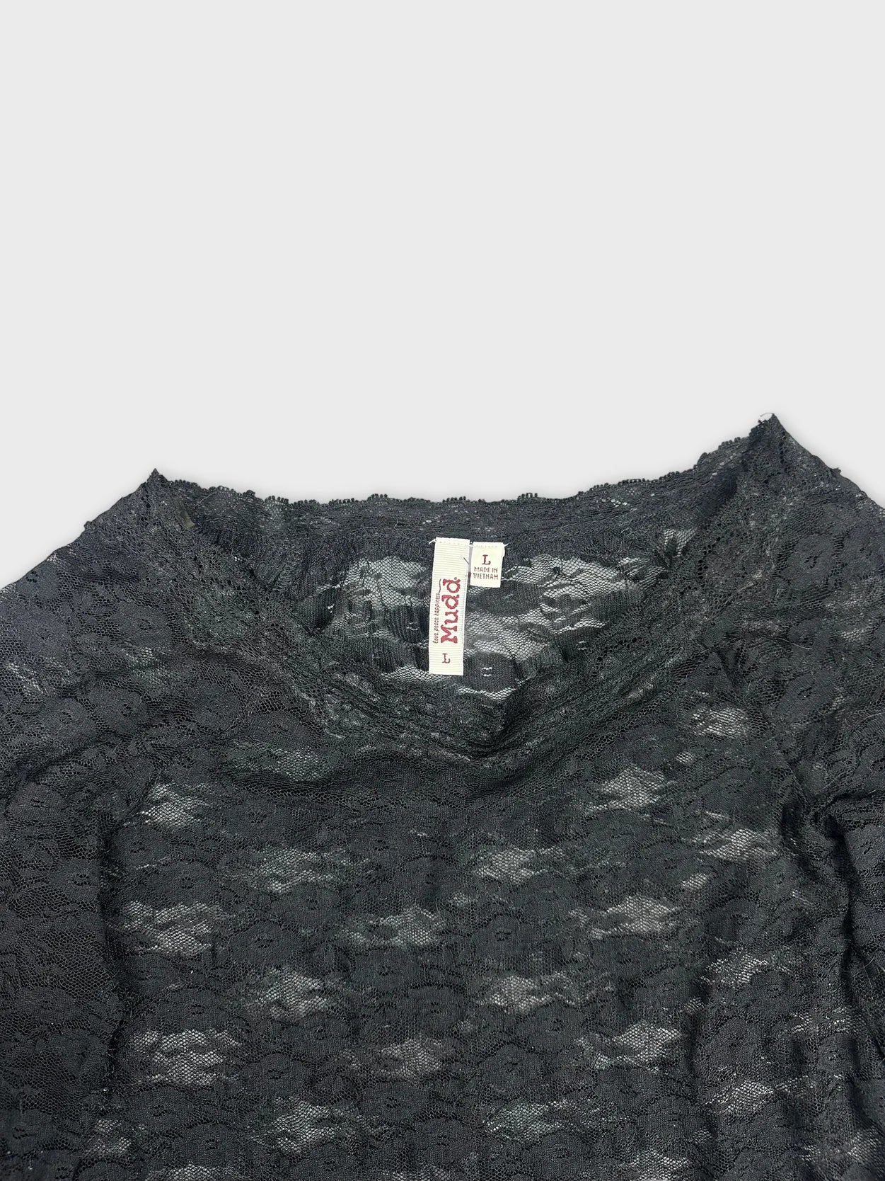 Detail view of a black long sleeve lace blouse with sheer texture.