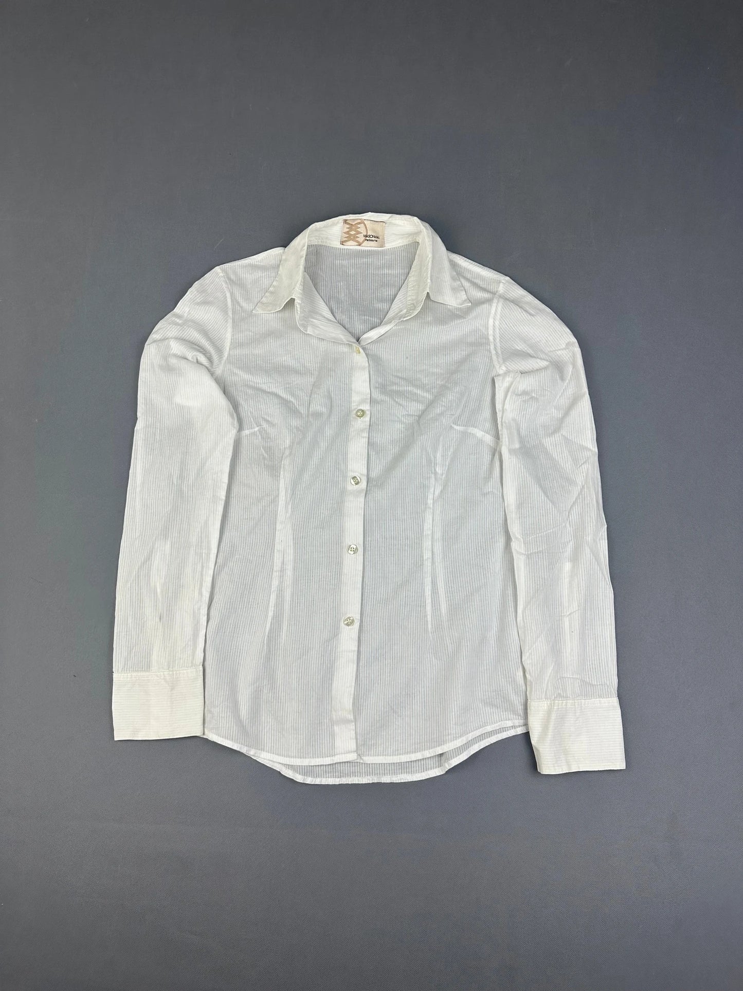 Detail view of a white long sleeve button up shirt with striped pattern.