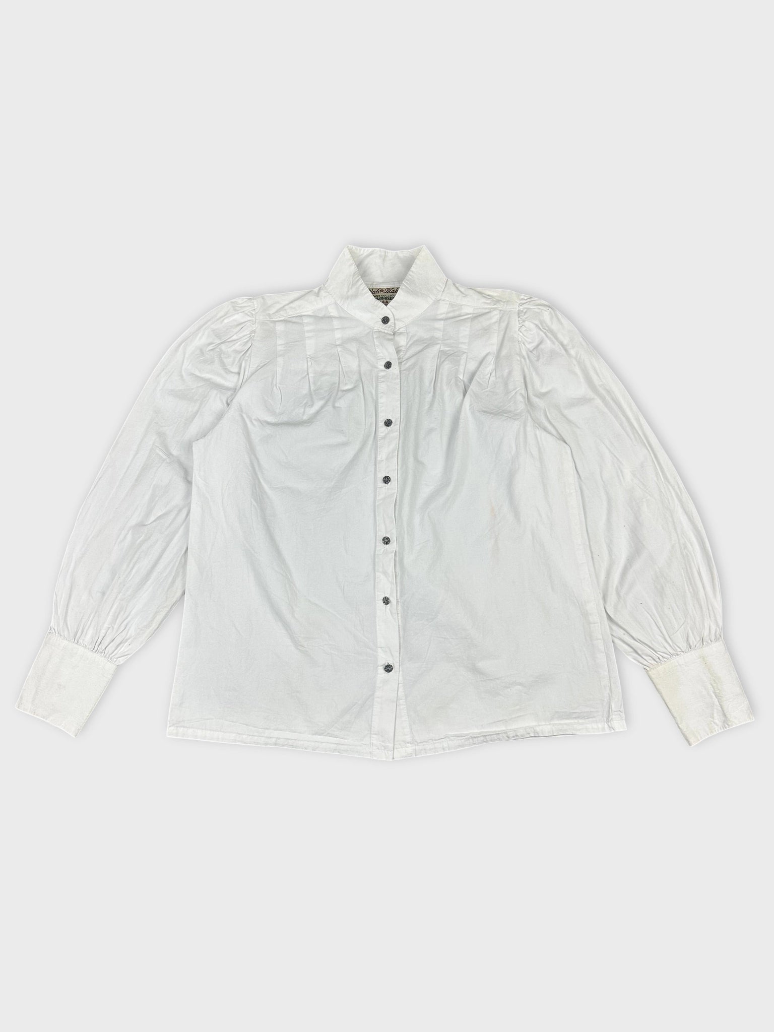 Front view of a white long sleeve button-up shirt with pleated shoulders.