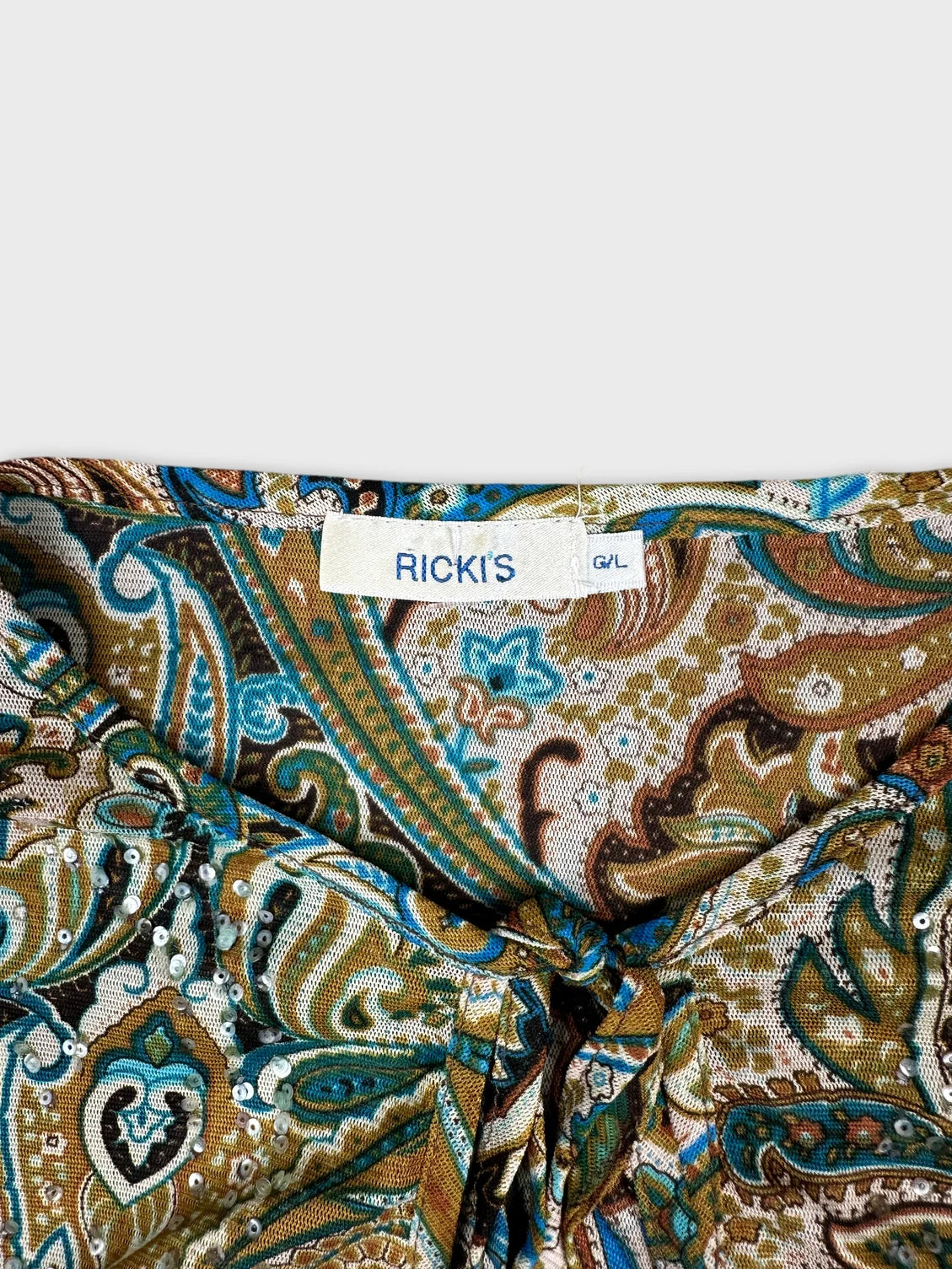detail view of a woman's long sleeve shirt in brown and blue paisley pattern