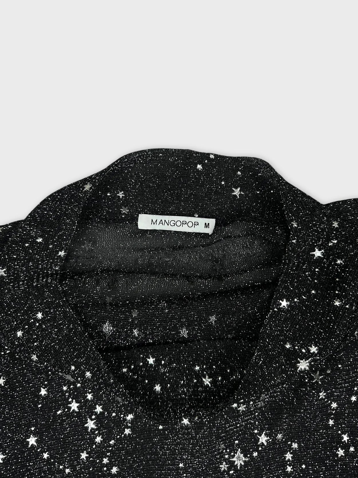 Detail view of a long sleeve black shirt with star print.