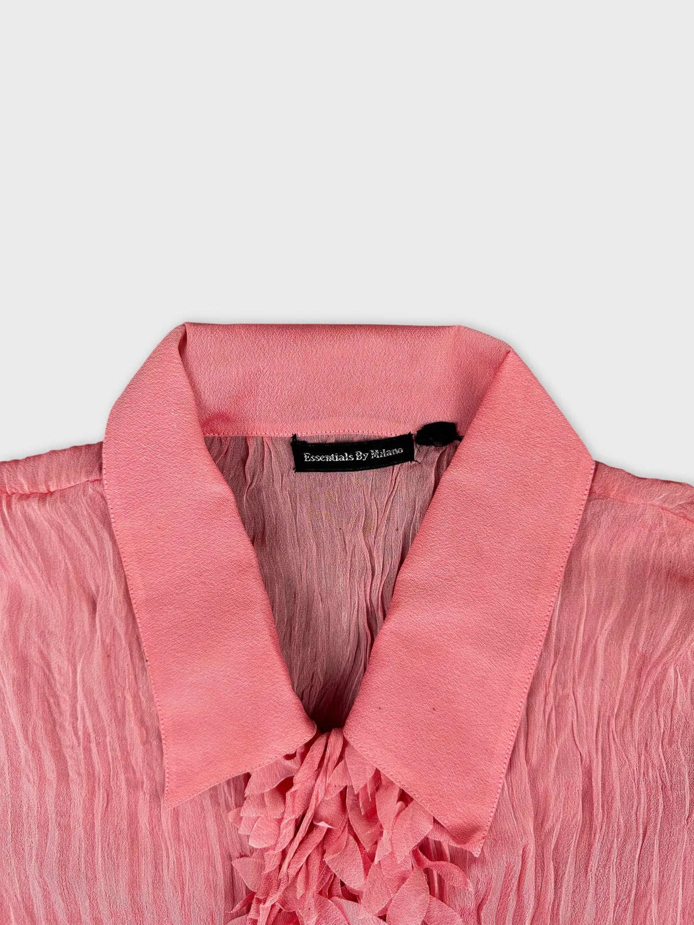 Detail view of a pink long sleeve shirt with textured trim.