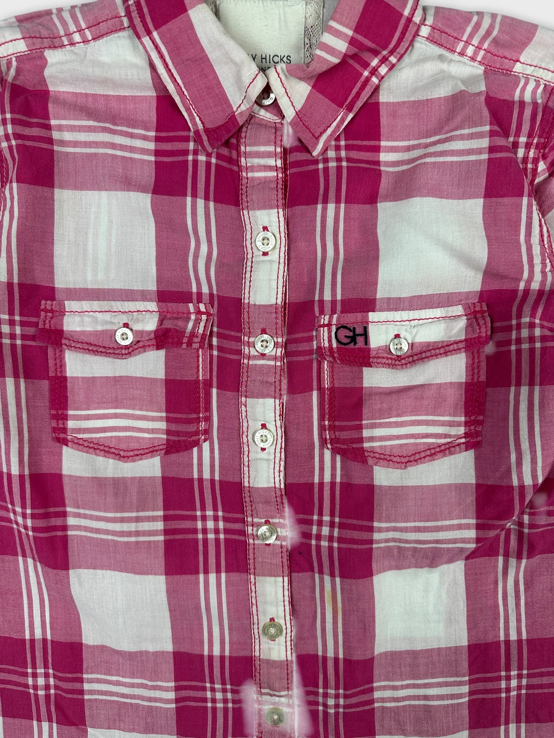 Detail view of a women long sleeve shirt in pink plaid pattern.