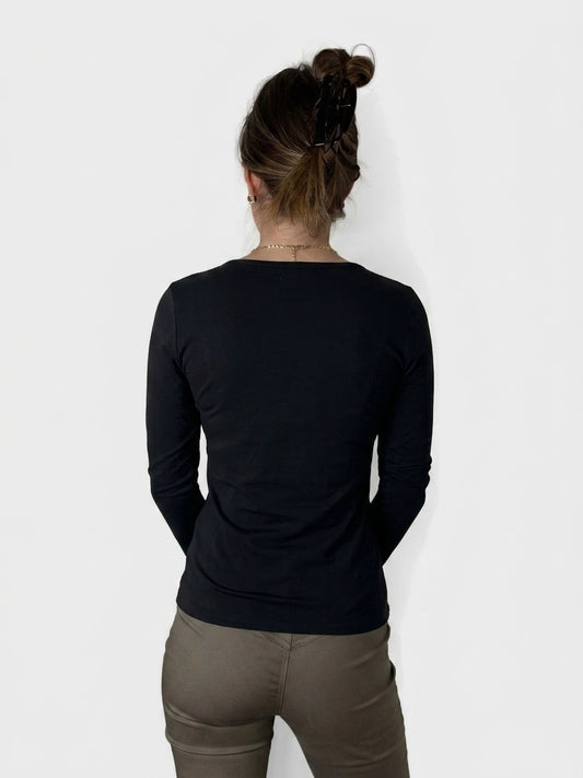 Black long sleeve shirt with a simple neckline, back view.