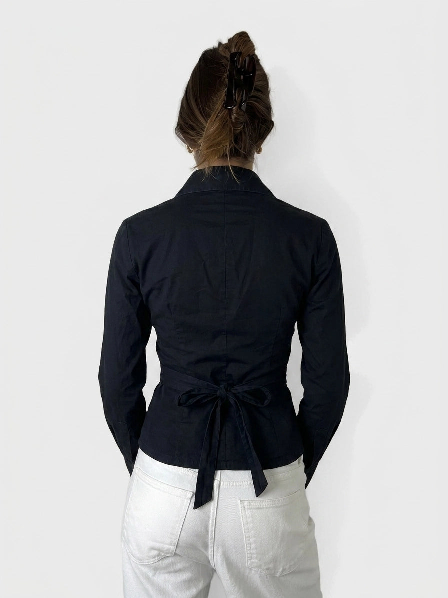 Back view of a navy long sleeve shirt featuring a tied waist detail.