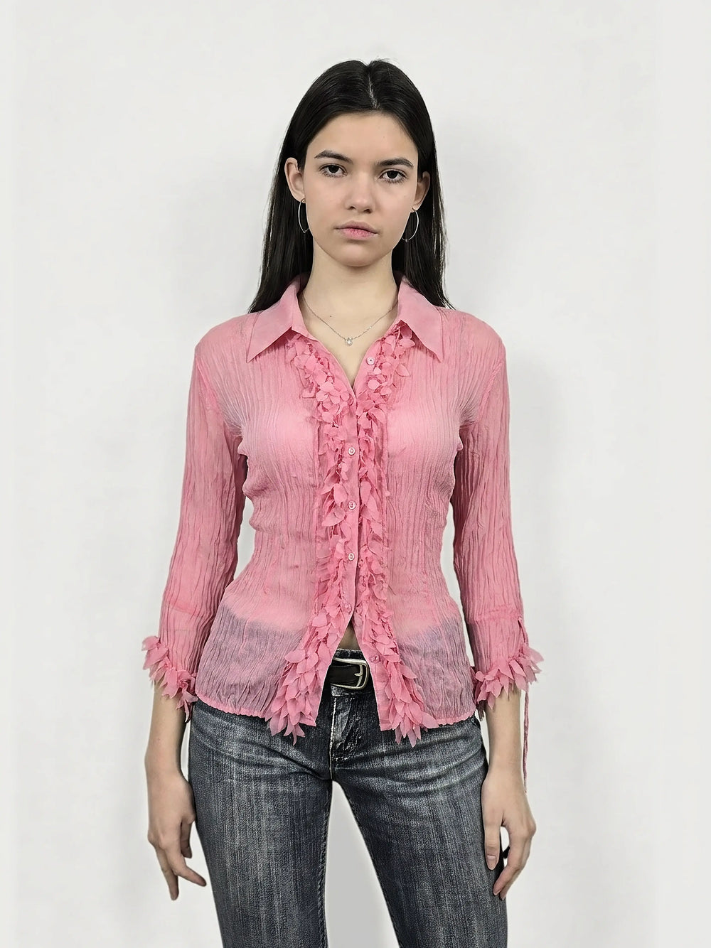 Front view of a pink long sleeve shirt featuring ruffled trim.