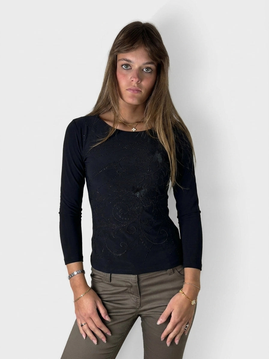 Front view of a women's long sleeve black shirt featuring intricate sparkly detailing.