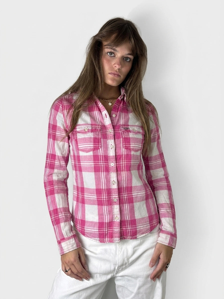 Front view of a pink plaid long sleeve shirt with button details.