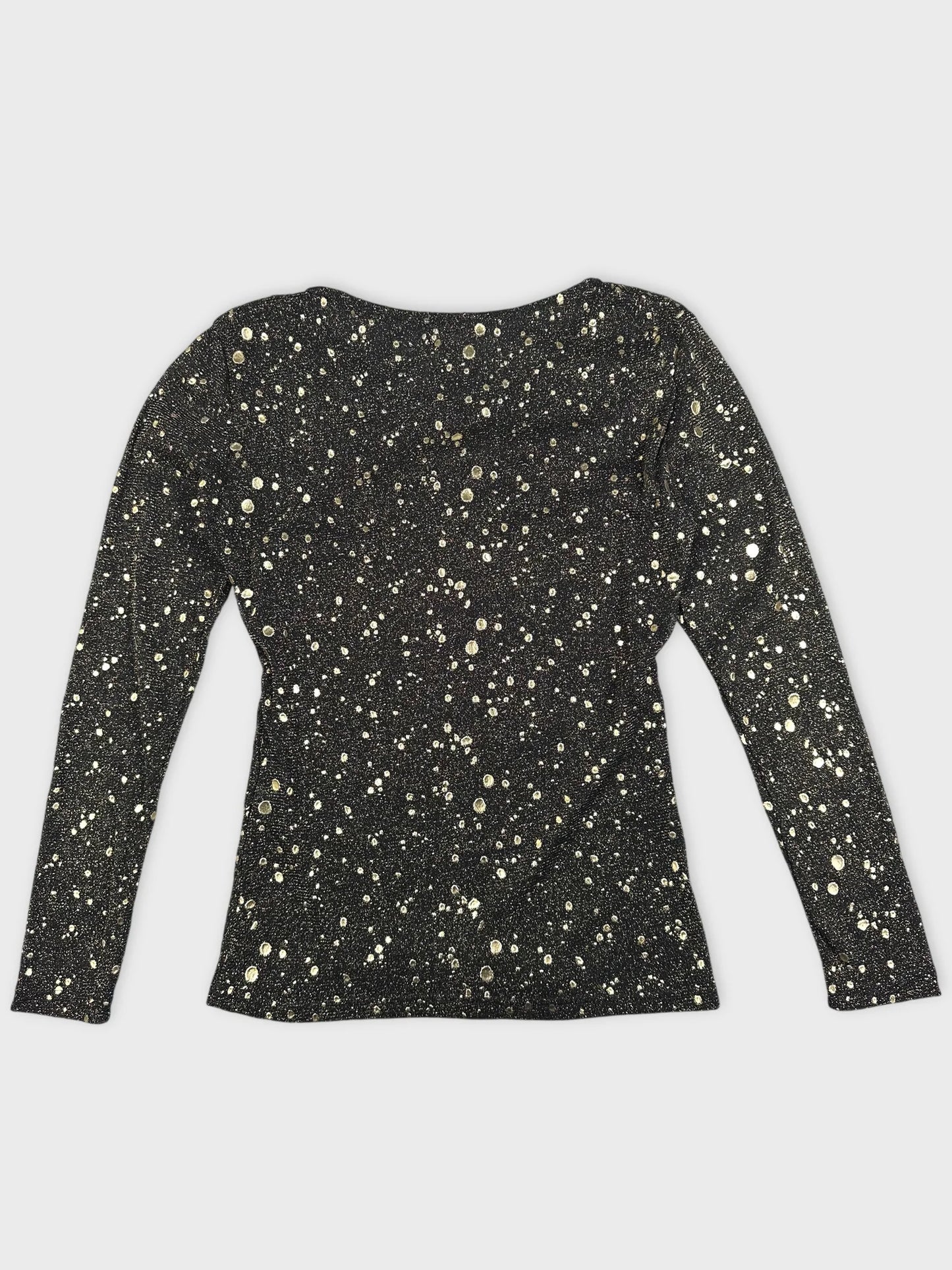 Back view of a long sleeve black top with gold speckles.