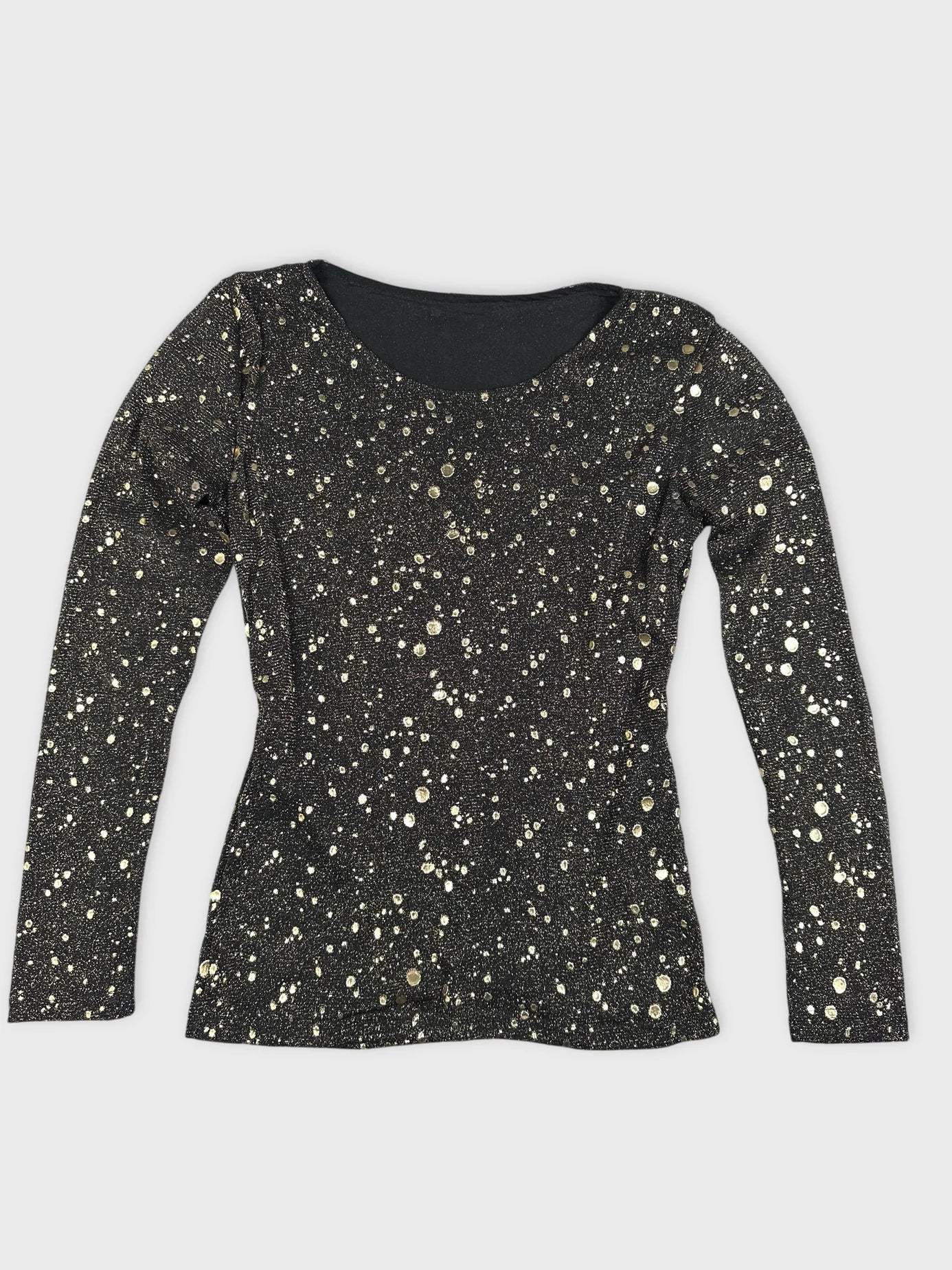 Detail view of a black long sleeve top with gold polka dots.