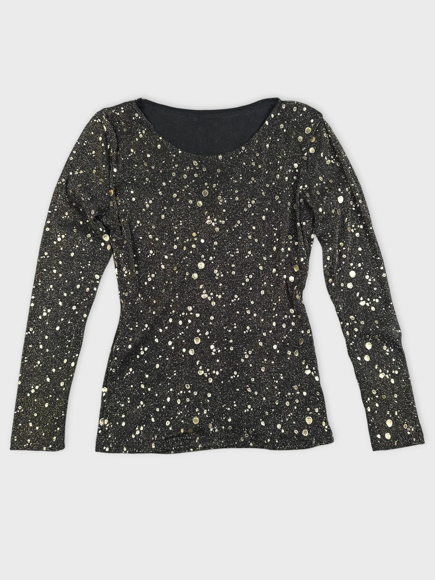 Detail view of a black long sleeve top with gold dot pattern.