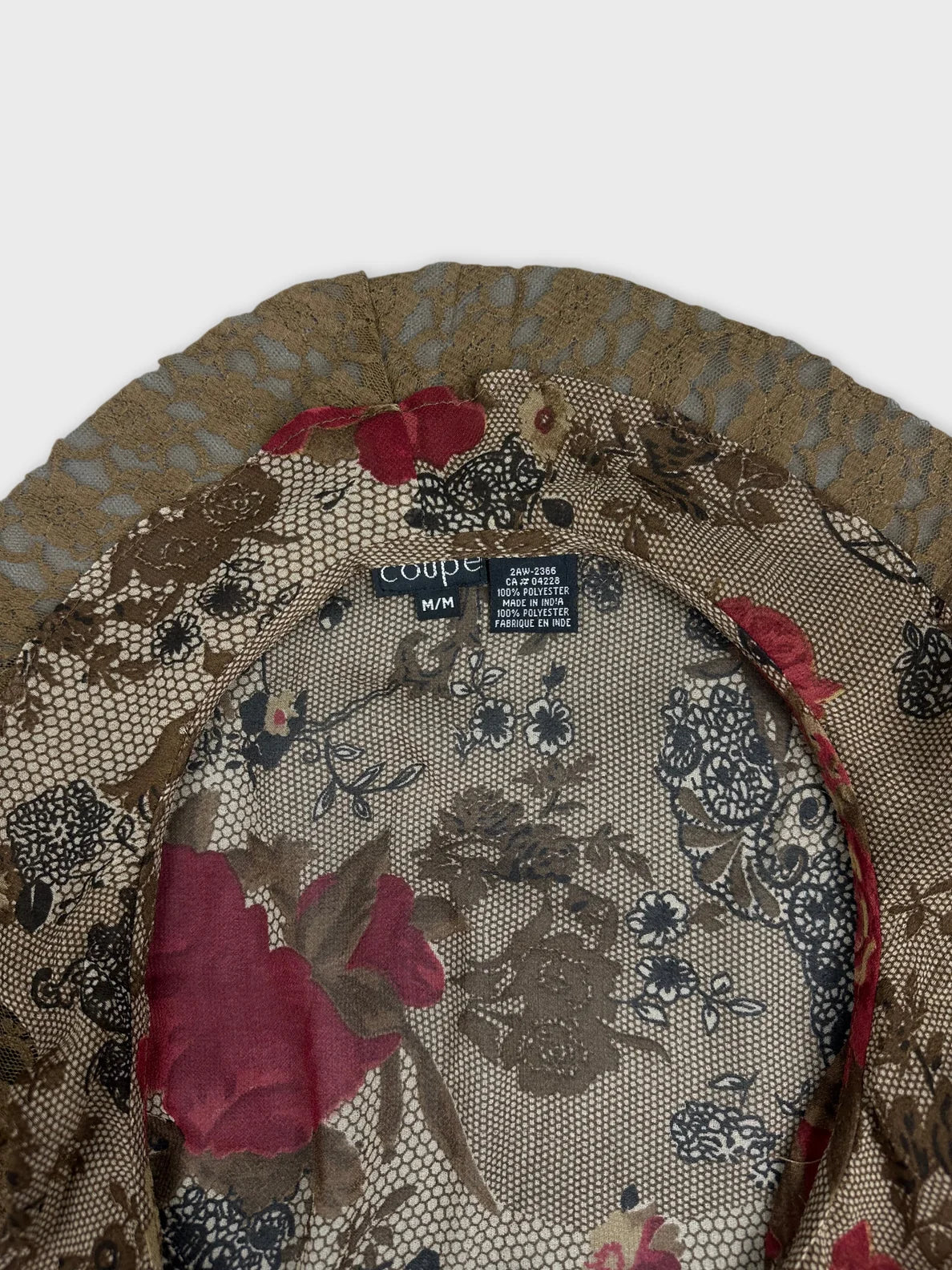 Detail view of a long sleeve top in brown with floral print.
