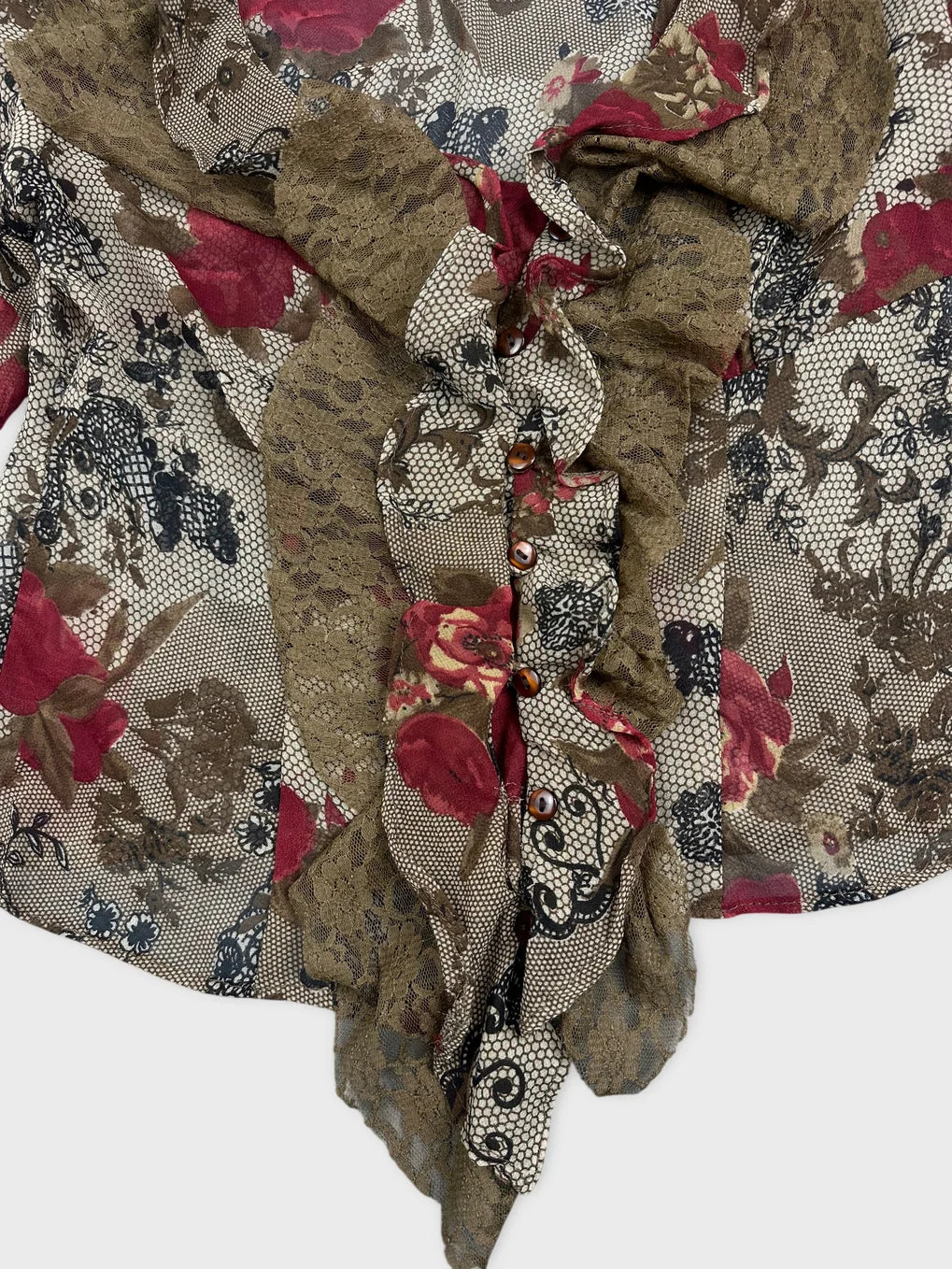 Detail view of a long sleeve top in earthy tones with floral print.