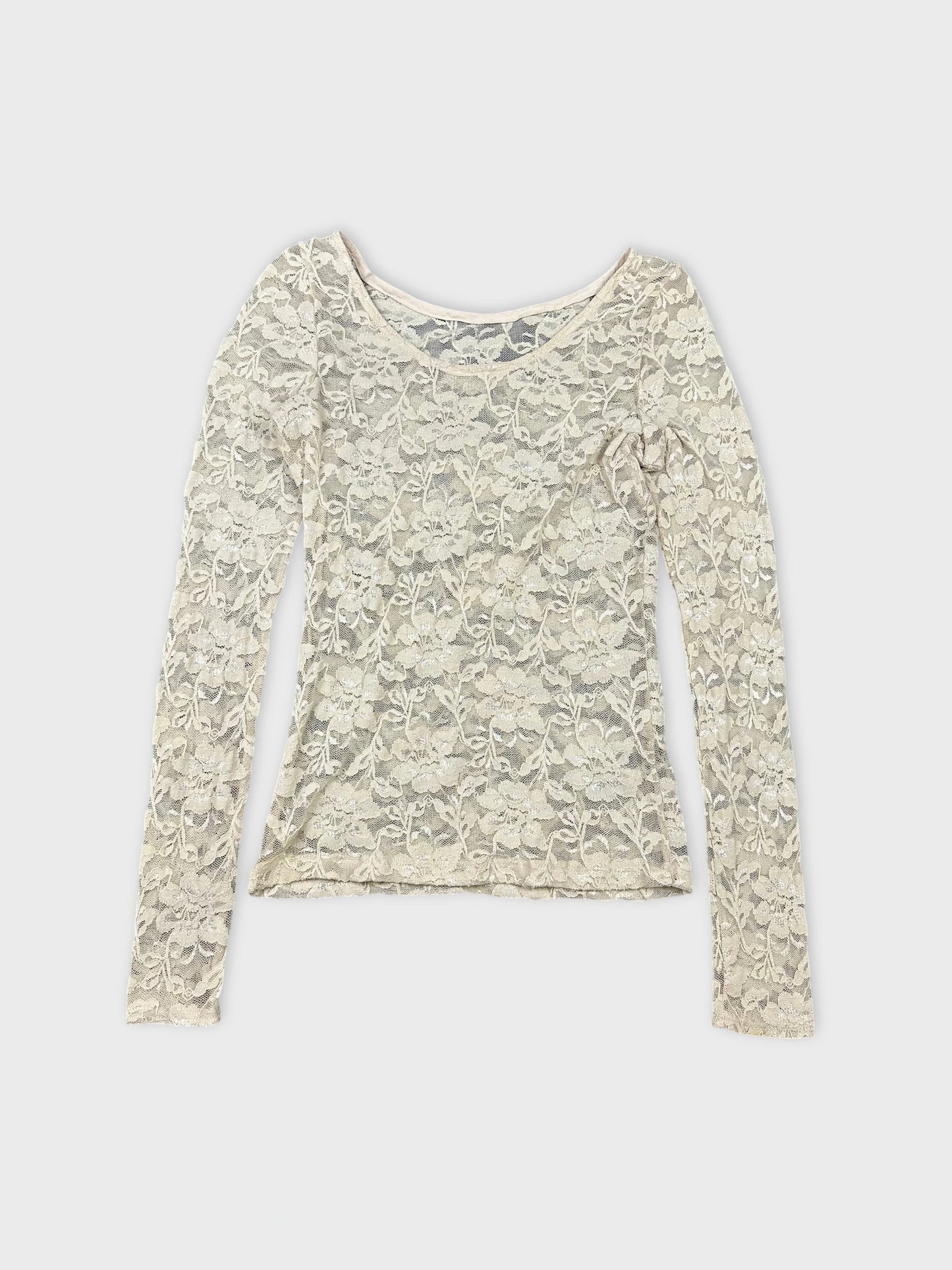 Detail view of a long sleeve lace top in off-white with floral pattern.