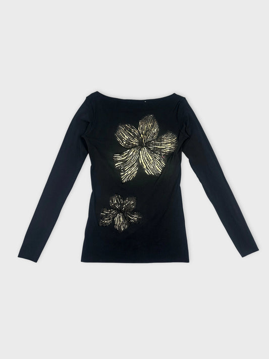 Front view of a black long sleeve top with gold floral print.