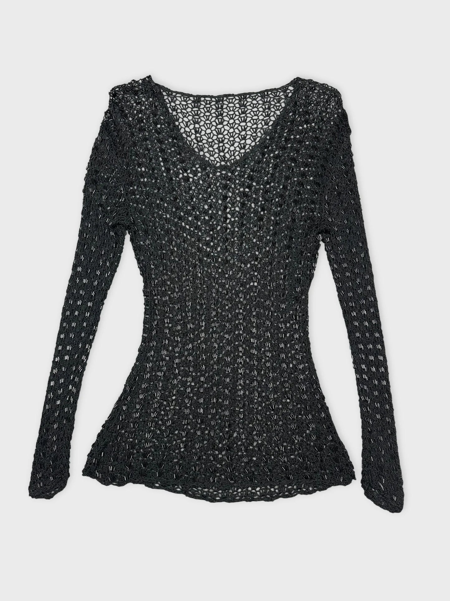 Black long sleeve top with open knit pattern in front view.