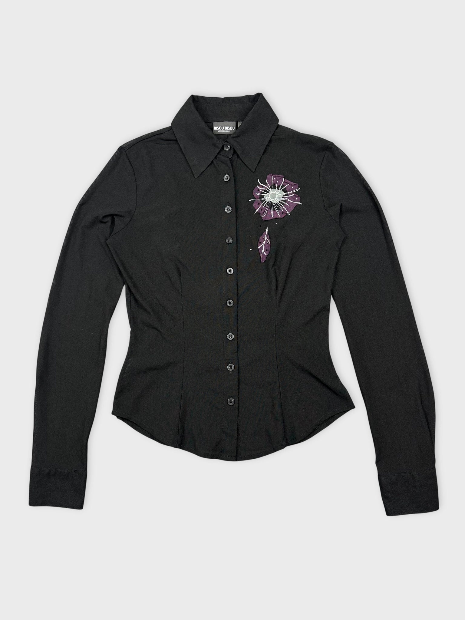 Front view of a black long sleeve top with floral embroidery detail.