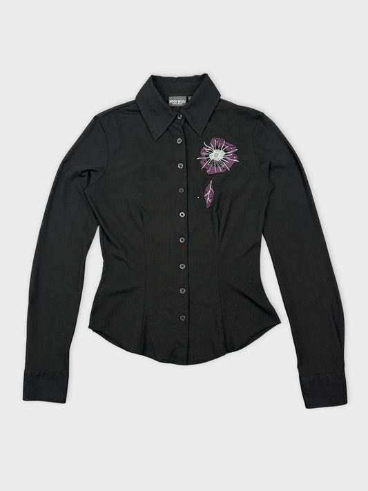 Front view of a black long sleeve top with floral embroidery detail.