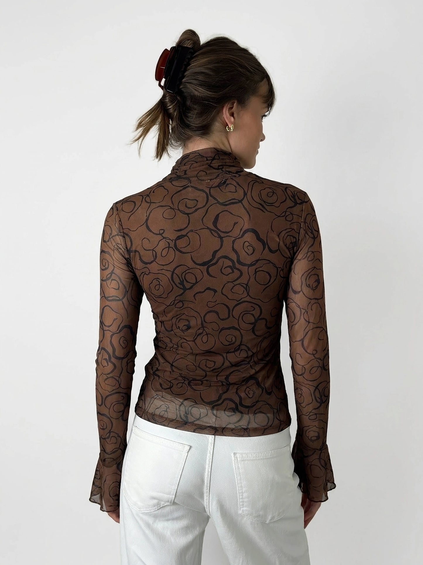 Back view of a long sleeve brown top with a floral pattern.