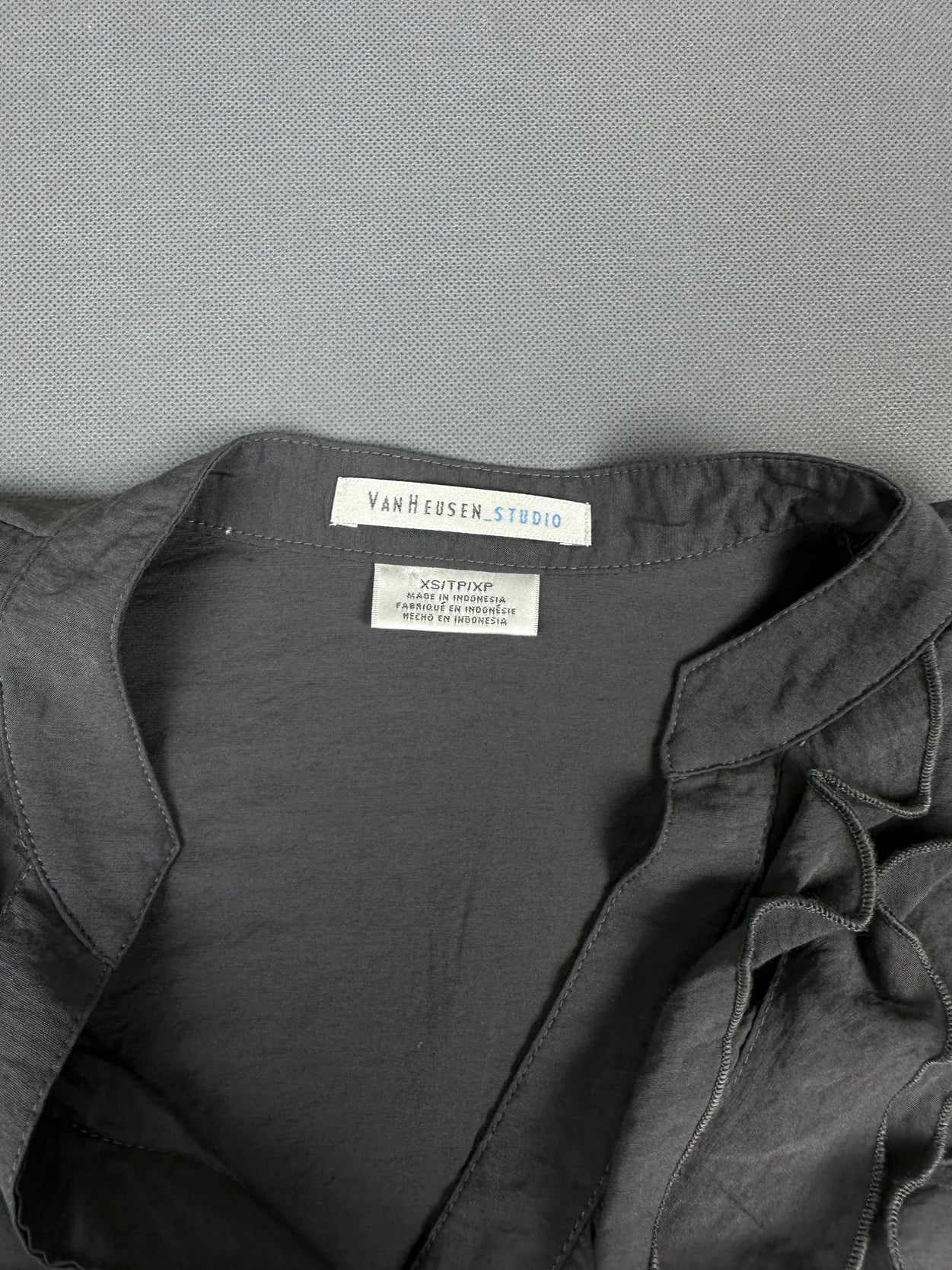 Detail view of a black short sleeve shirt featuring a classic collar.