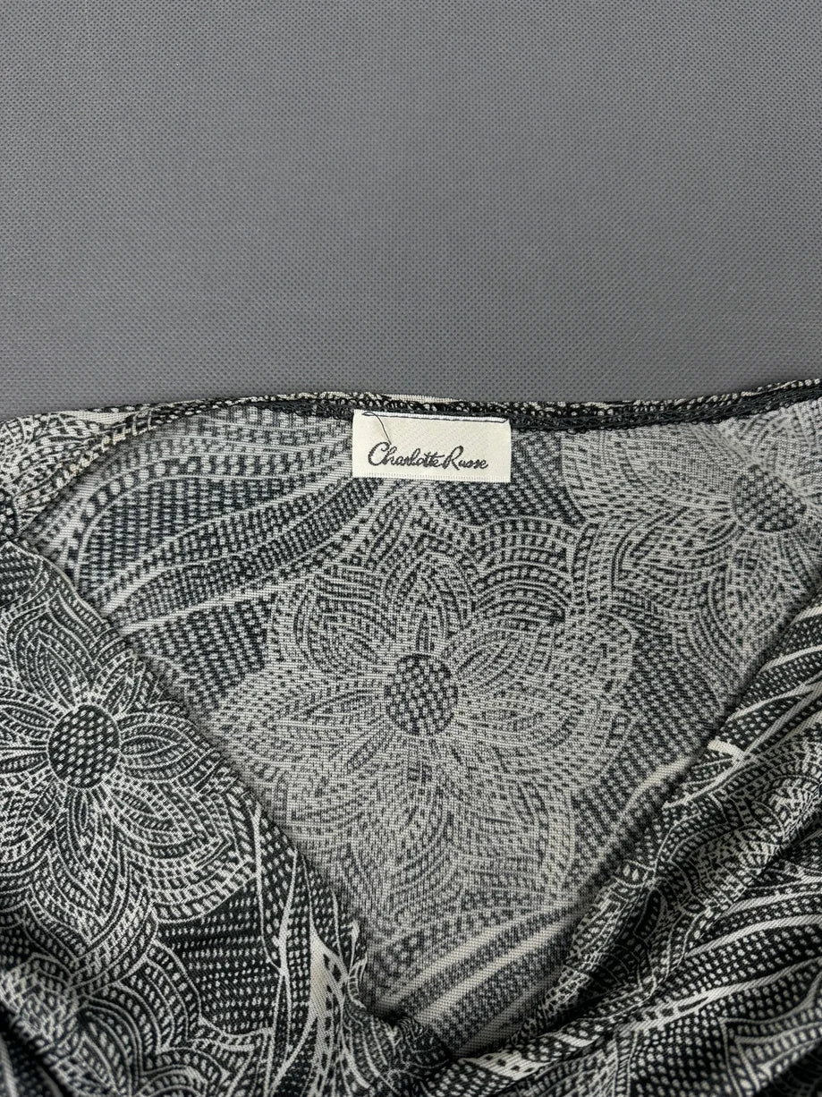 Detail view of women's short sleeve top in black and white floral pattern.