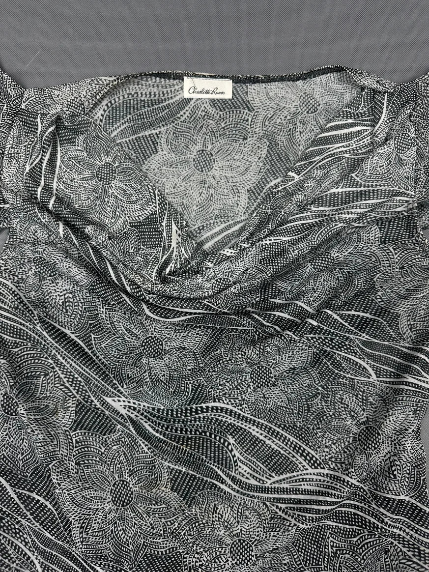 Detail view of a short sleeve black and white floral patterned top.