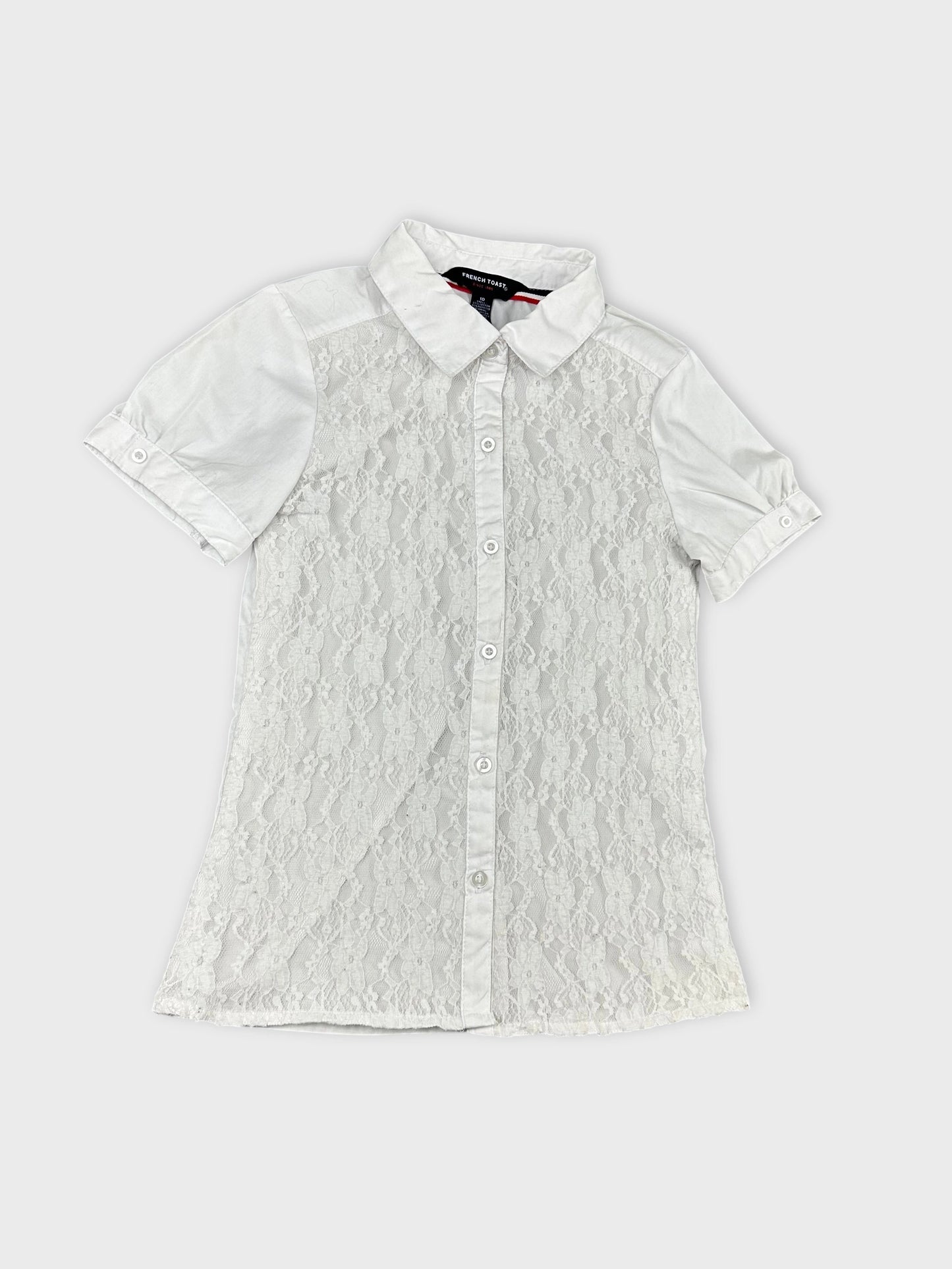 Detail view of a white short sleeve shirt with lace overlay.