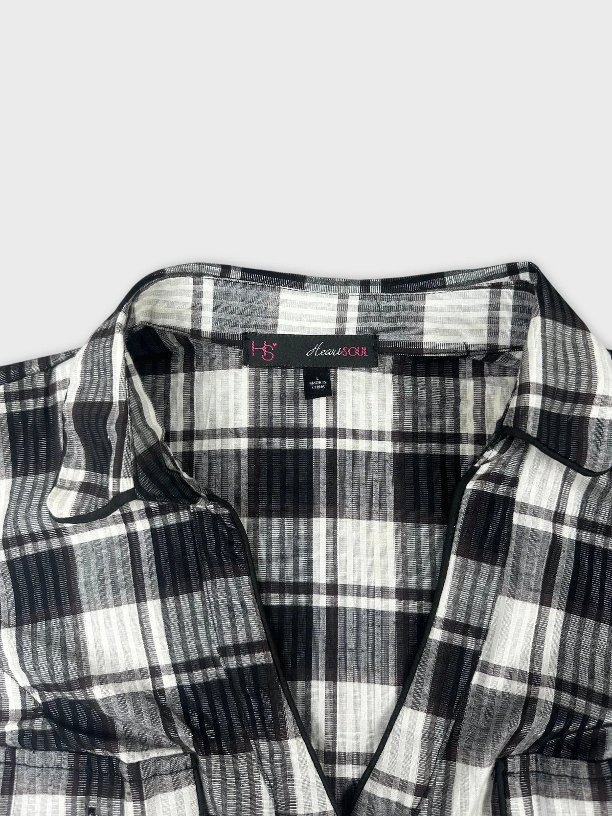 Detail view of a black and white plaid women’s short sleeve shirt.