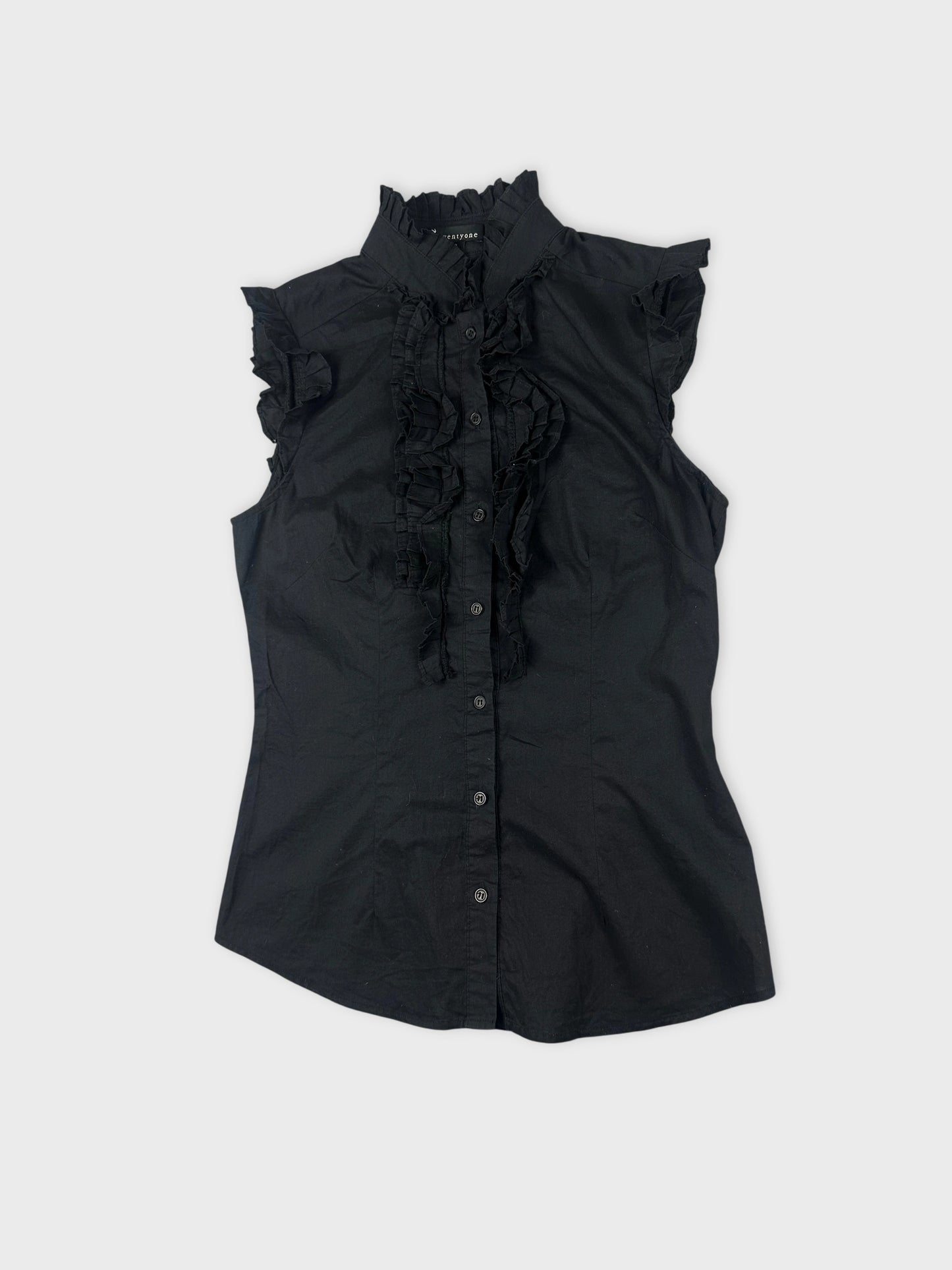 Detail view of a black sleeveless shirt with ruffled trim.