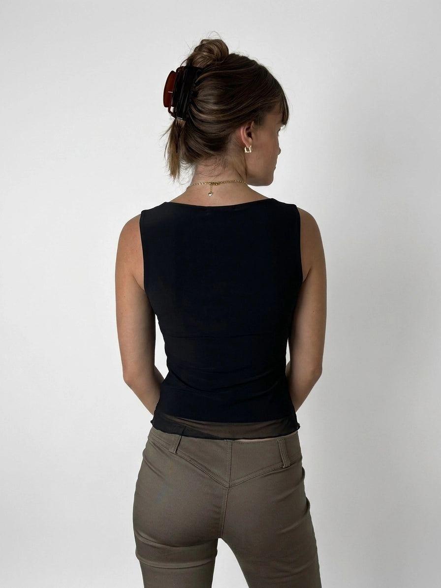 Black sleeveless top with sheer trim, back view.
