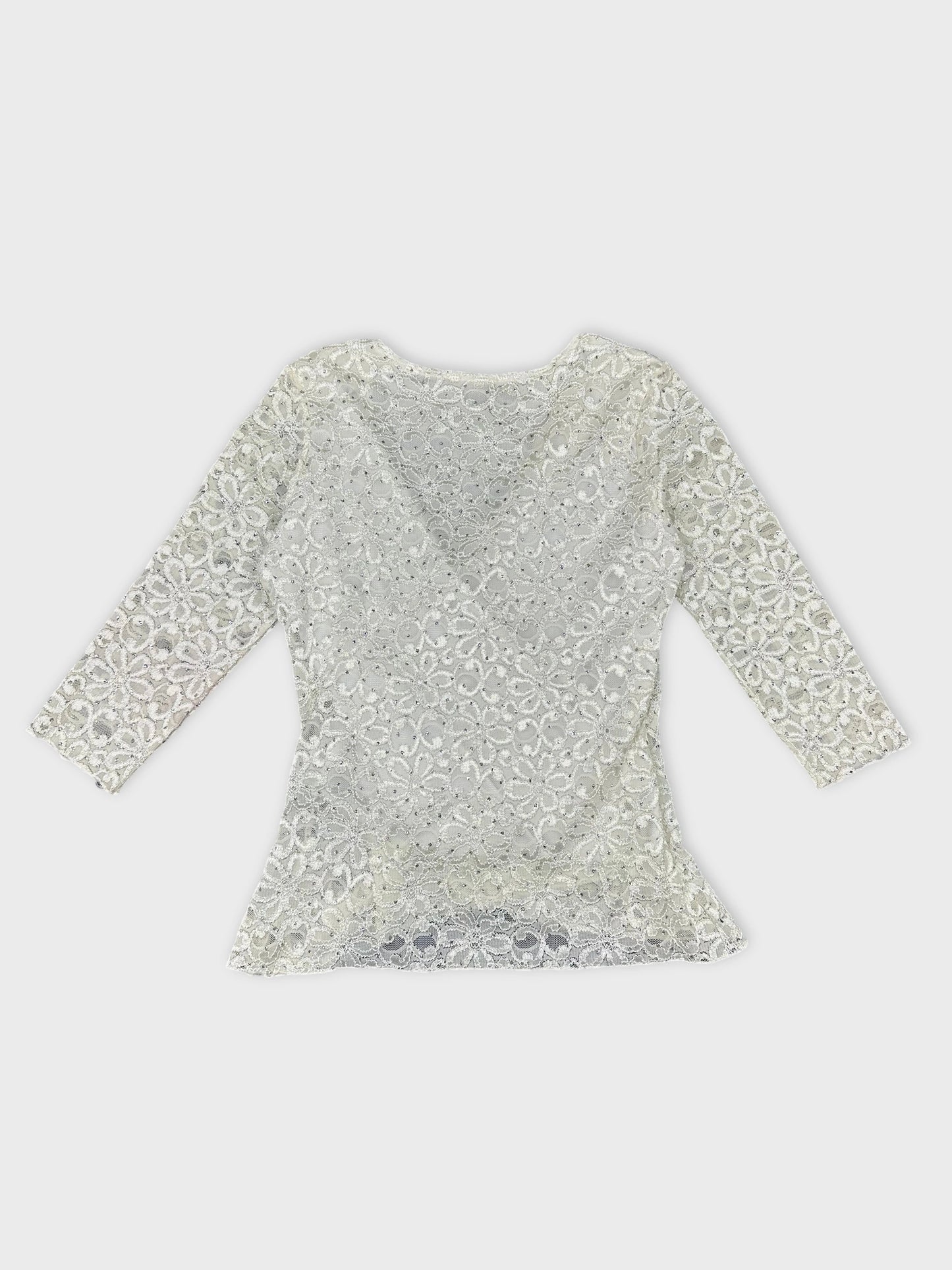 Back view of a white short sleeve top with floral lace pattern.