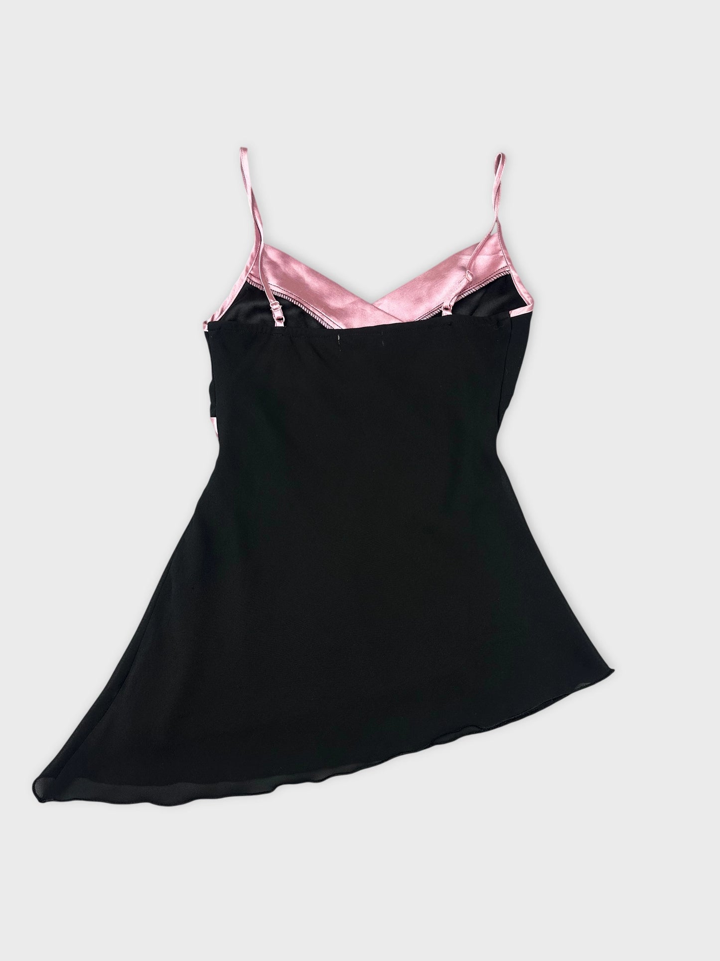Back view of a black women’s top with pink satin straps.
