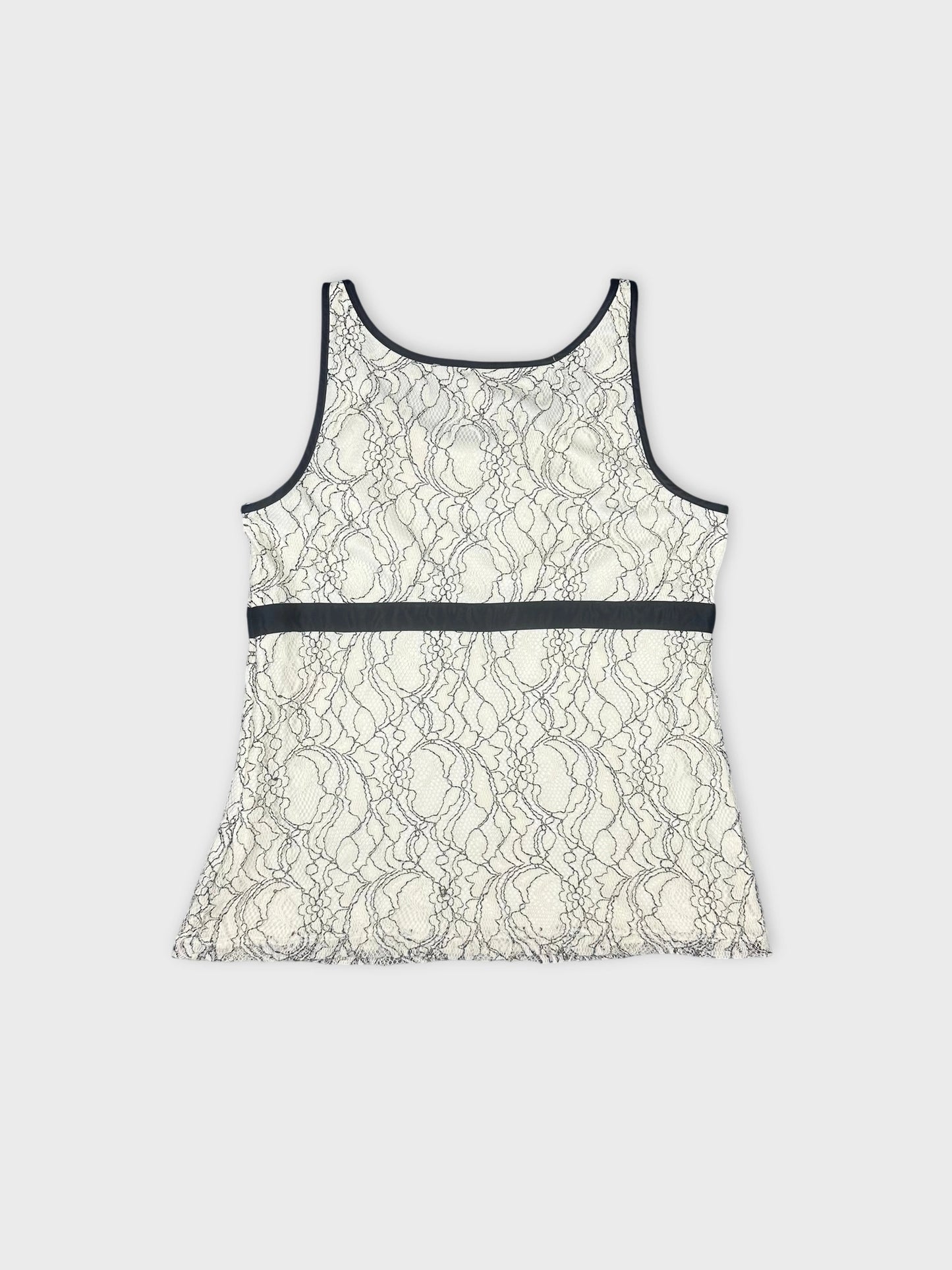 Back view of a lace tank top featuring cream color with a black trim.