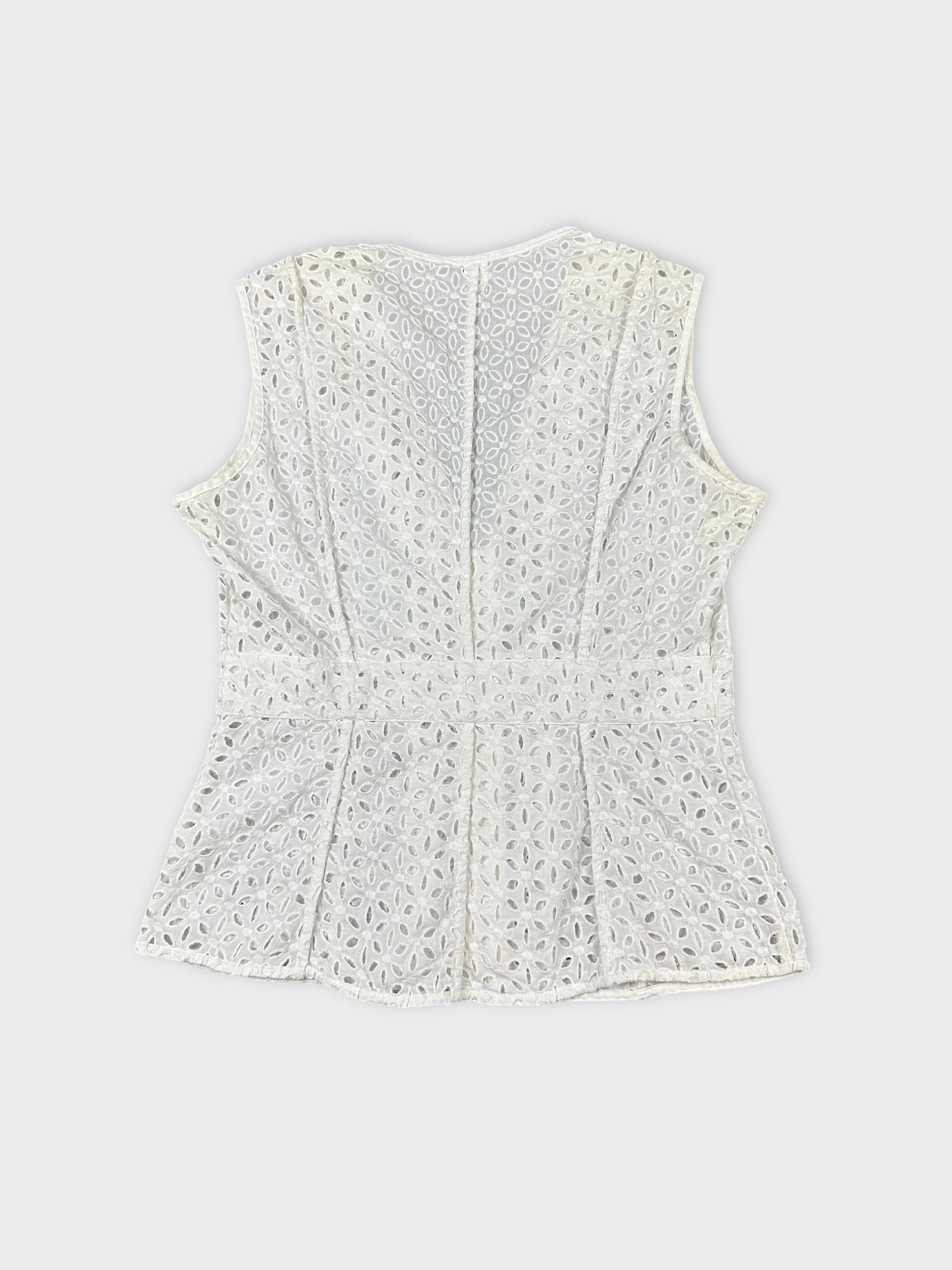 Back view of a women’s sleeveless top in white with eyelet pattern.