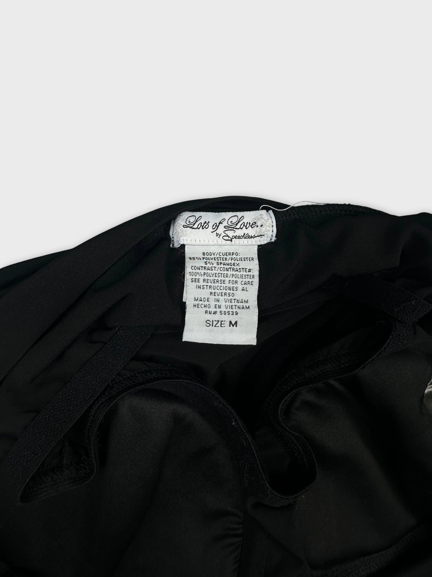 Detail view of women's black shorts sleeve tops with tag visible.