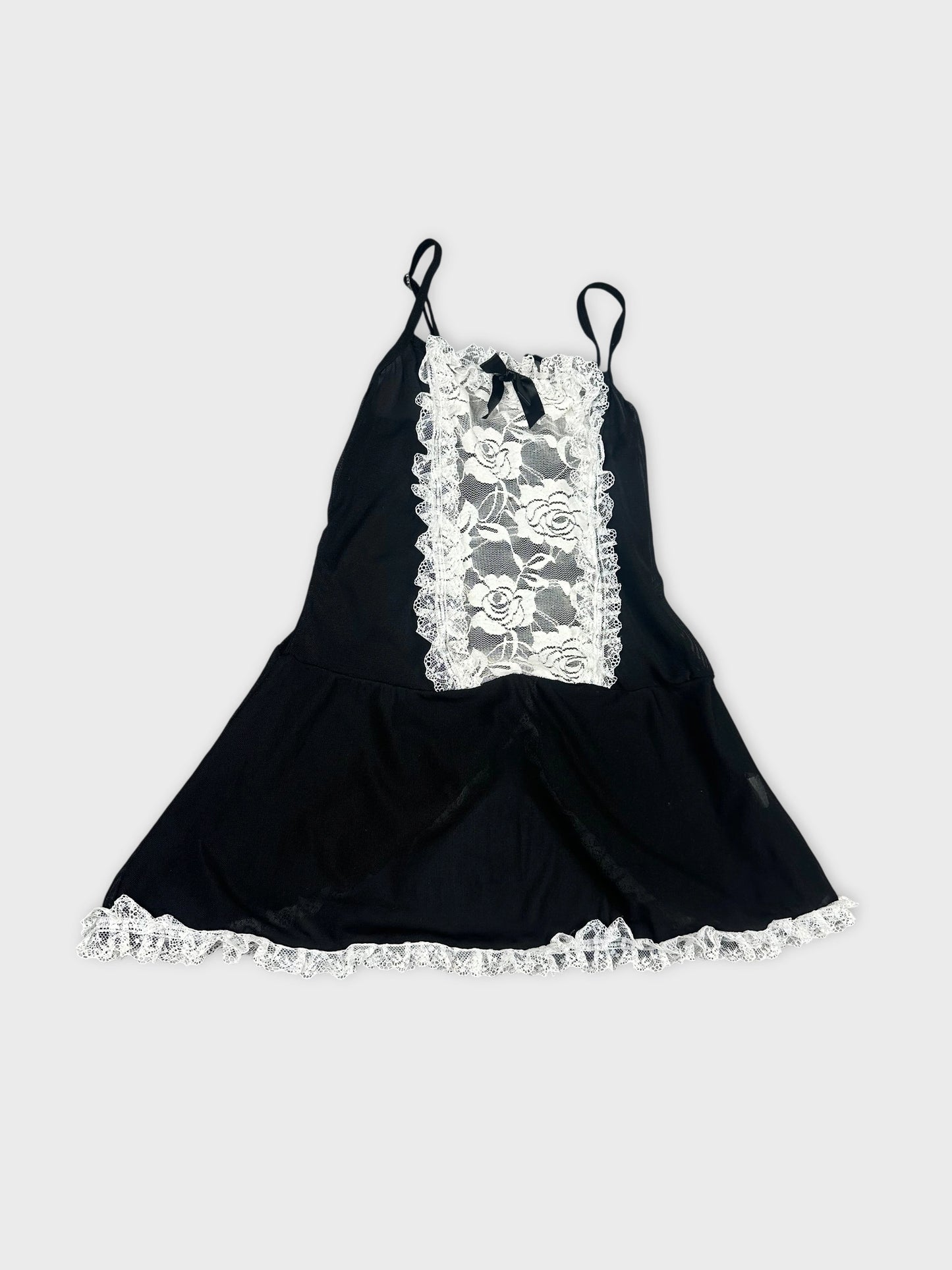 Detail view of black women’s top with lace trim and floral pattern.