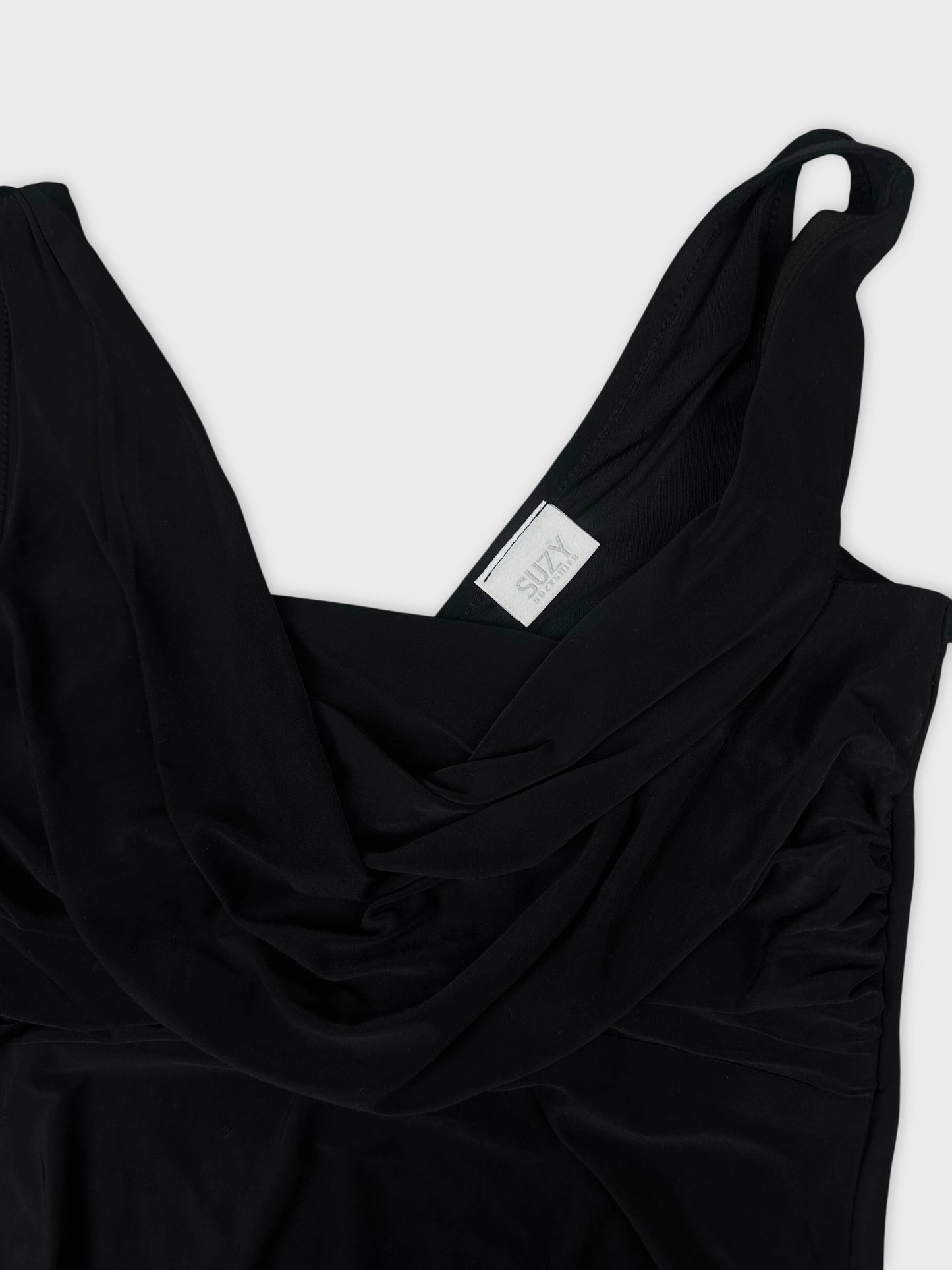 Detail view of a black women's top featuring draped design and scoop neckline.