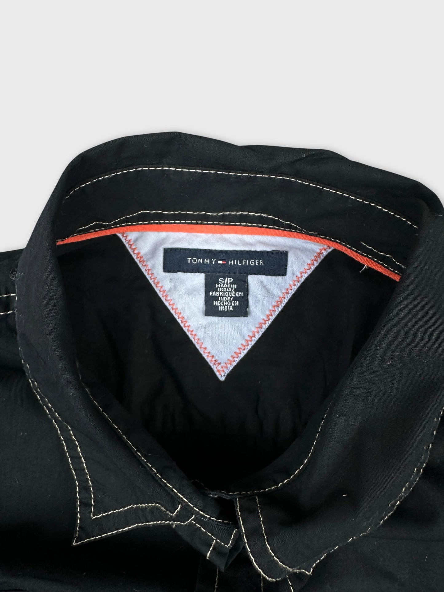 detail view of a black women's short sleeve top with contrasting stitching