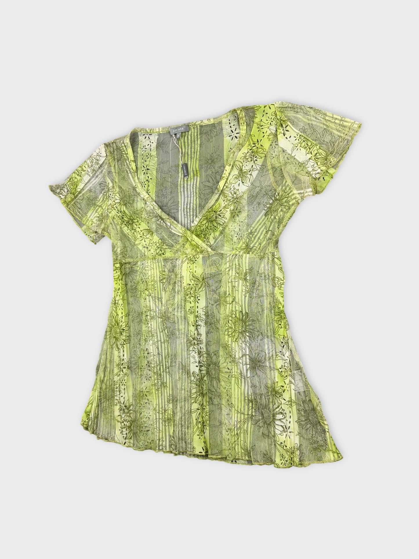 Detail view of a short sleeve top in green with floral print.