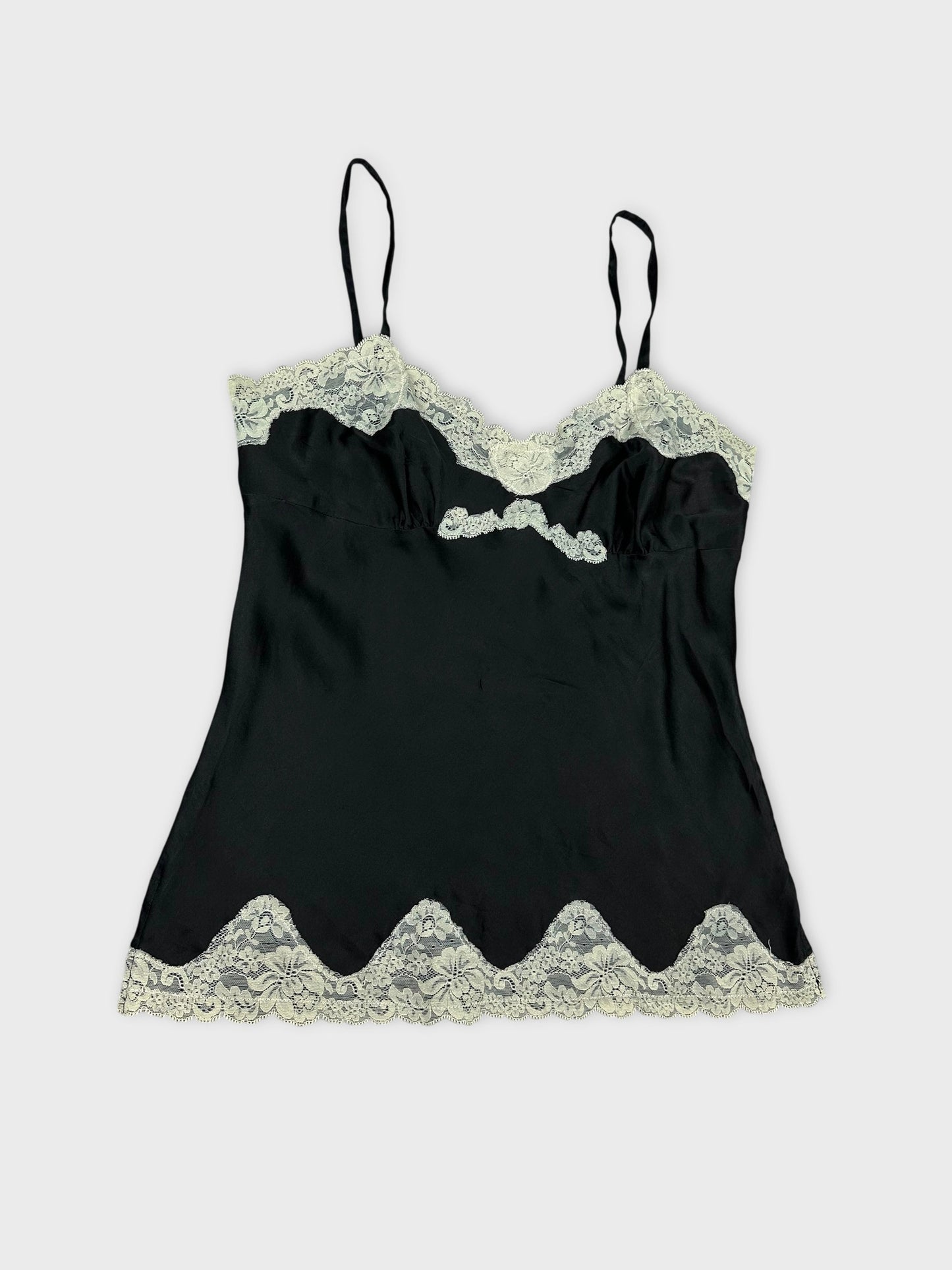 Detail view of a black satin camisole with floral lace trim.