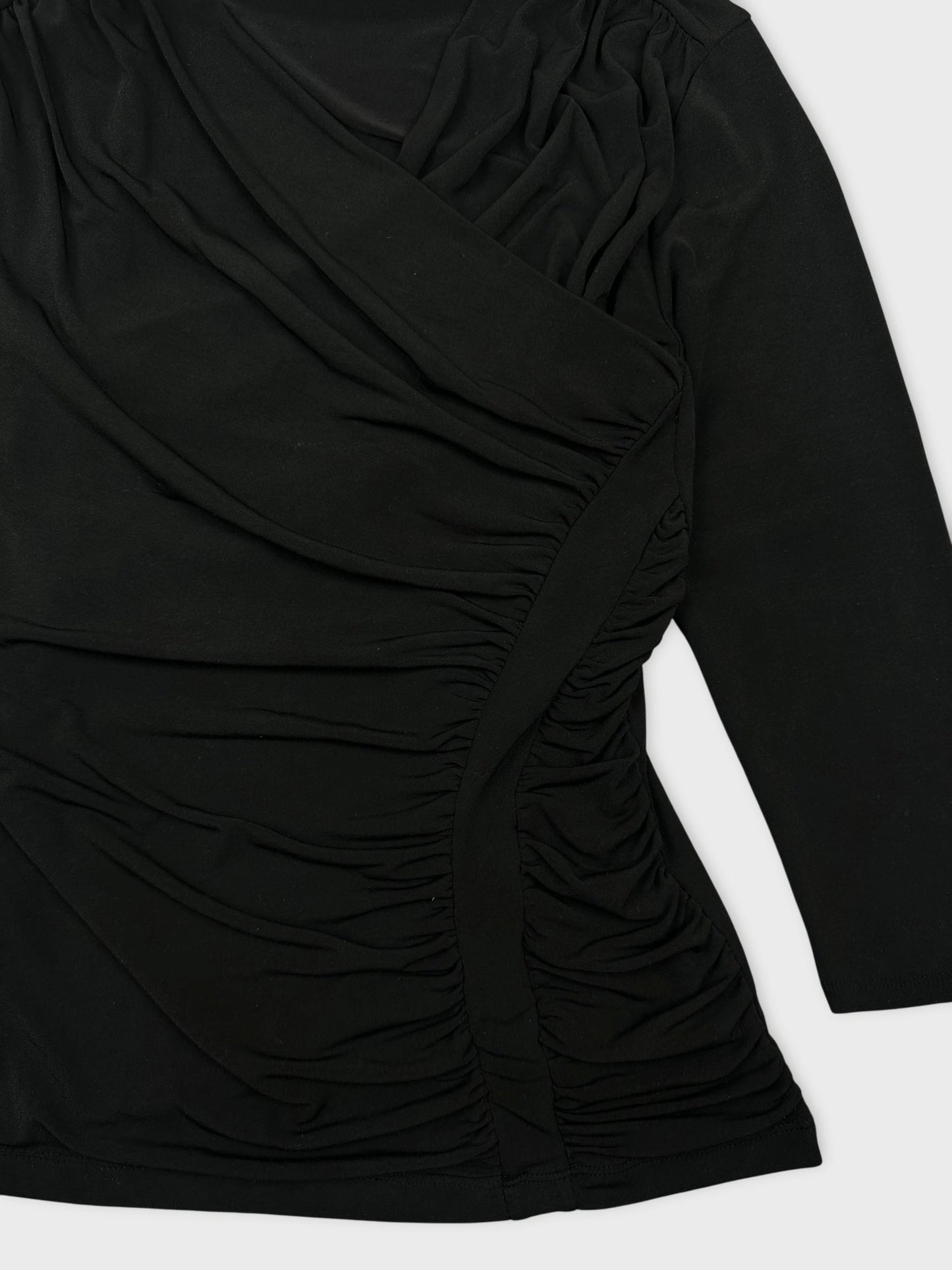 Detail view of black women's top with gathered fabric design.