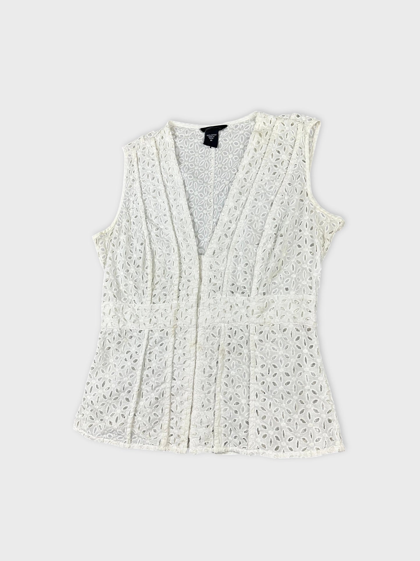 Detail view of a white vintage sleeveless top with floral lace pattern.